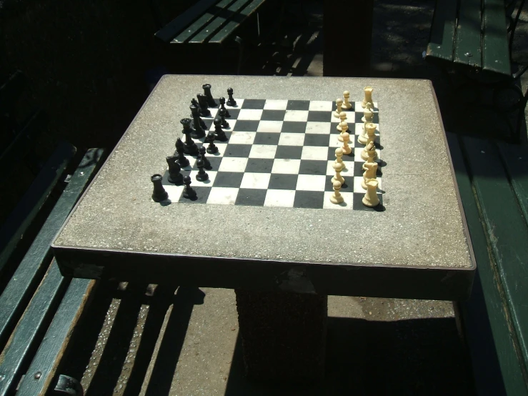the chess board is sitting on a bench