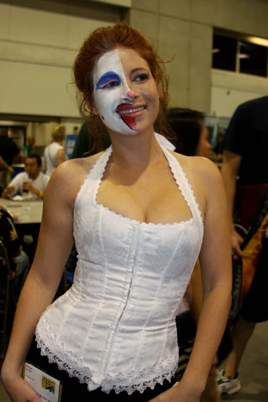 a woman with a clown makeup on has her face painted white