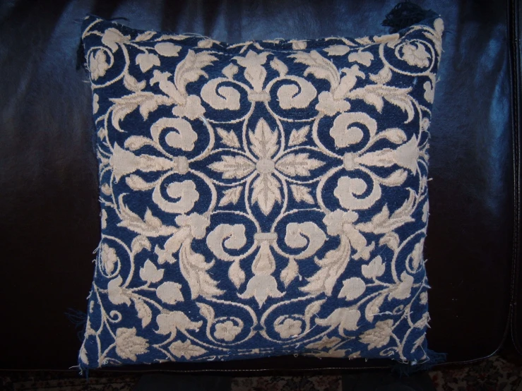 a blue and white pillow on top of a couch