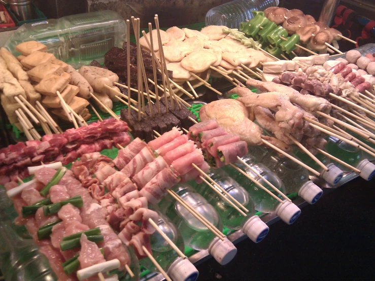 various food on sticks are displayed in a market