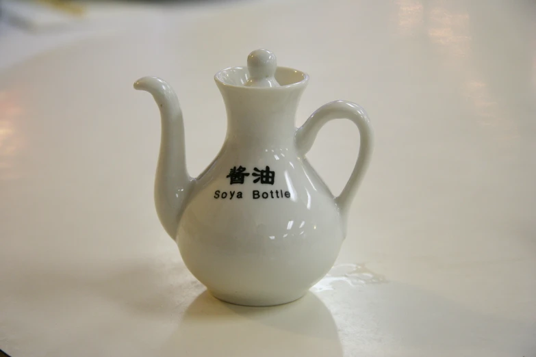 white ceramic bottle decorated with a japanese character