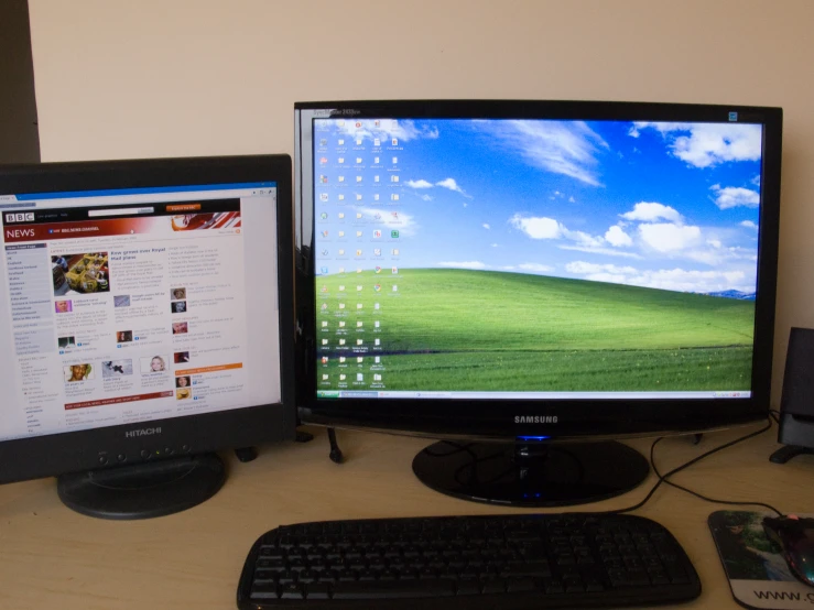 two computer monitors sitting next to each other on a desk