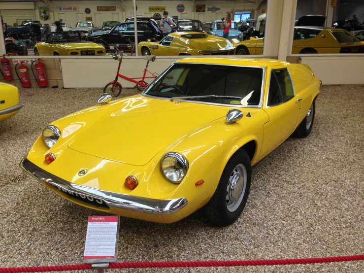 a yellow sports car sits in a showroom