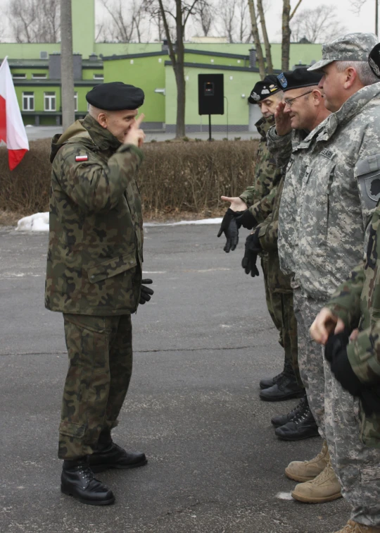 a man in military uniform is pointing to another man