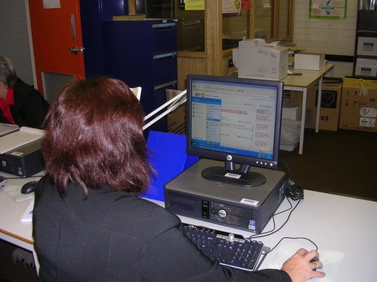 woman looking at computer screen with open folder