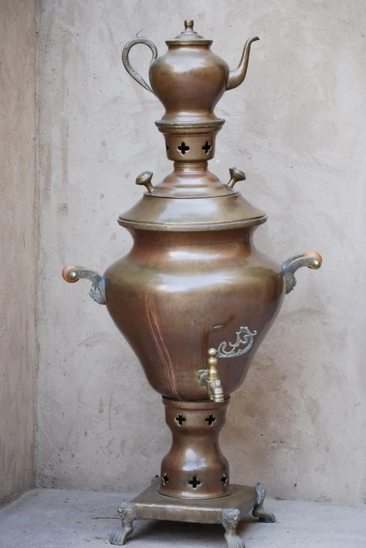 a small vase with a long handle is displayed