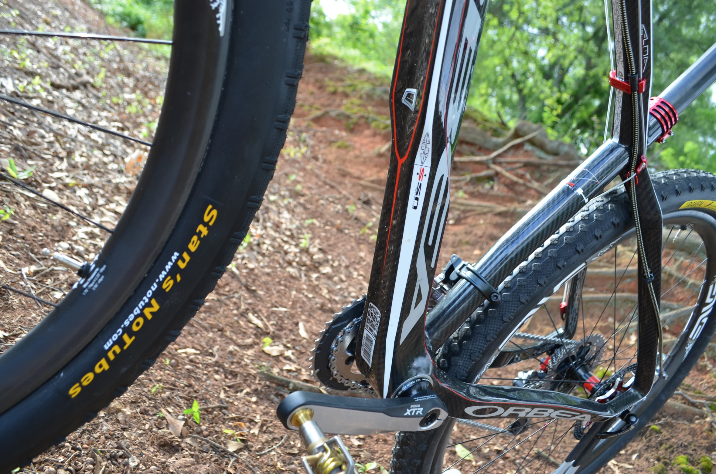 two bicycles standing side by side on a dirt trail