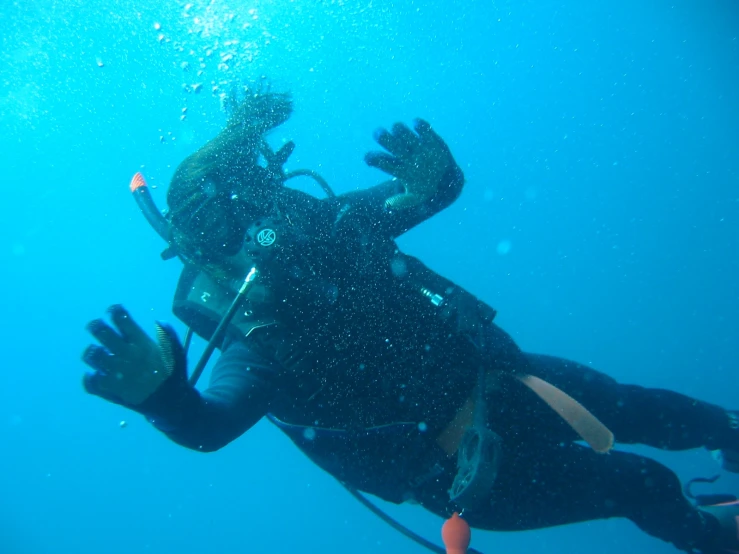 an underwater man swimming under the ocean while scubaing