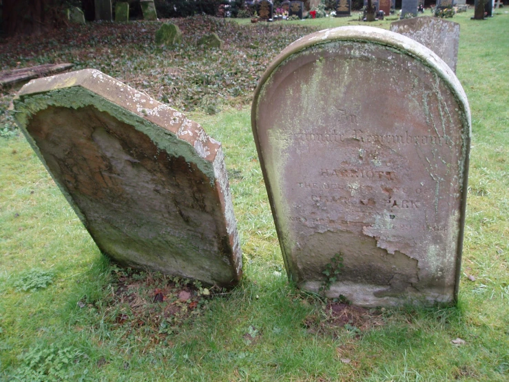 two old, stone headstones that are not very large