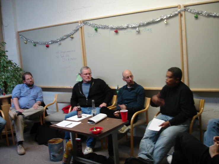 several people sitting at a table and writing notes