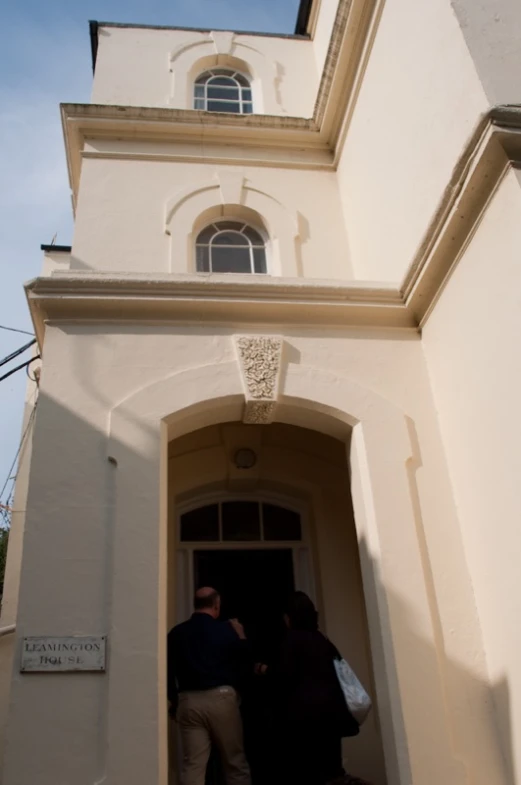 two people walking out of a church doorway