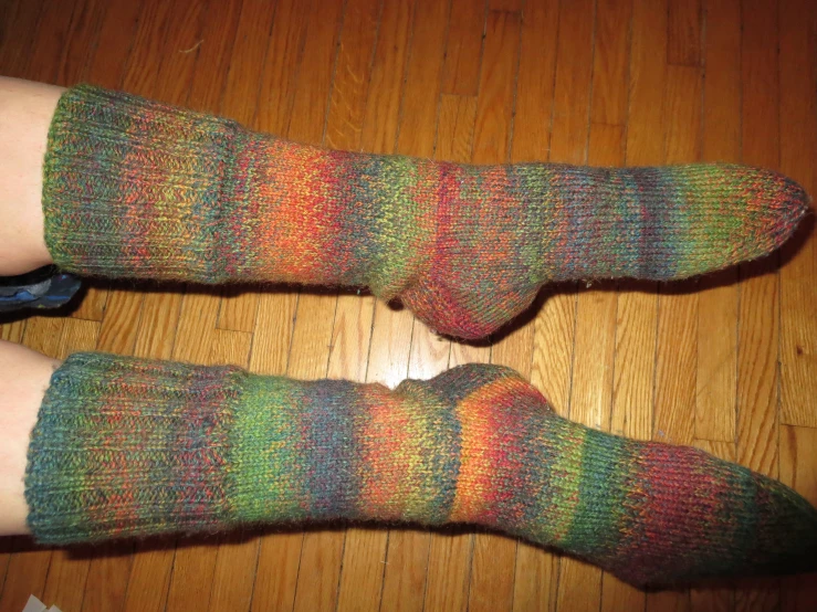 someone's legs wearing colorful socks in a pair of multi colored socks