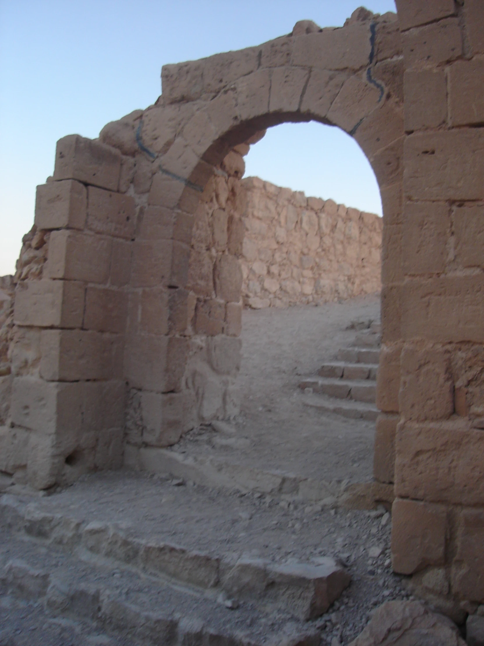 an ancient city with a stone arch and steps