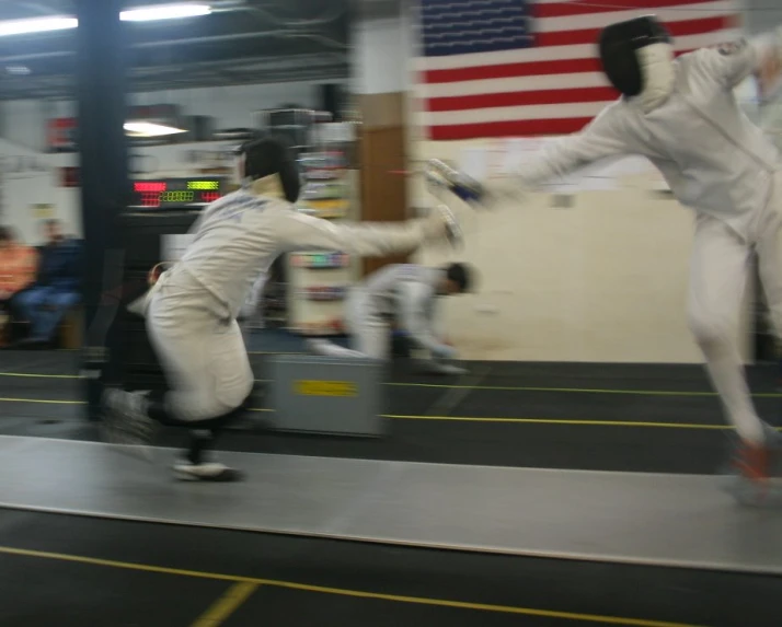 two men in white fighting in a gym