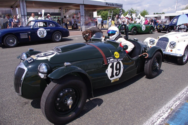 two vintage race cars with number thirteen on the side