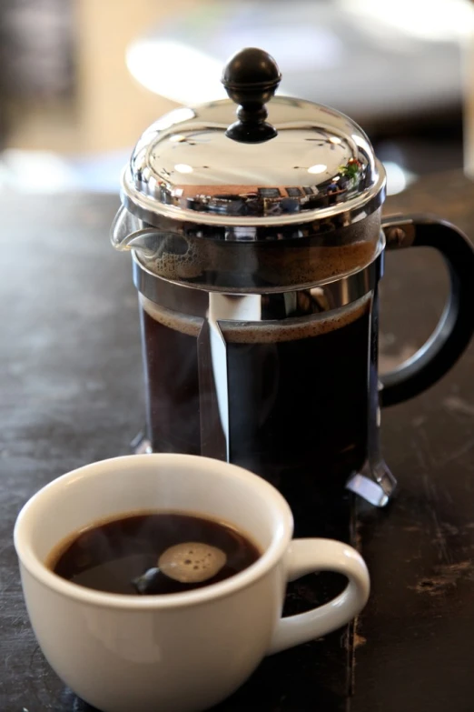 a cup of coffee sitting next to a machine