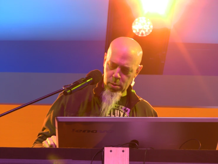 a man wearing headphones on stage with a laptop computer