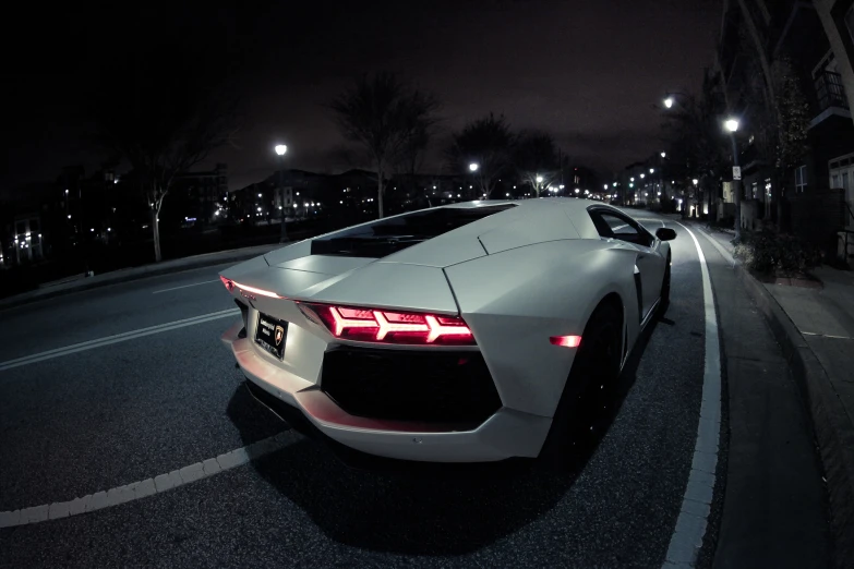 a very pretty white car on a dark street