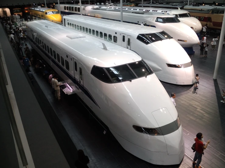 three white trains lined up at a railway station