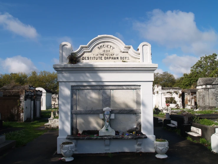 an old fashioned cemetery with a white clock and some headstones