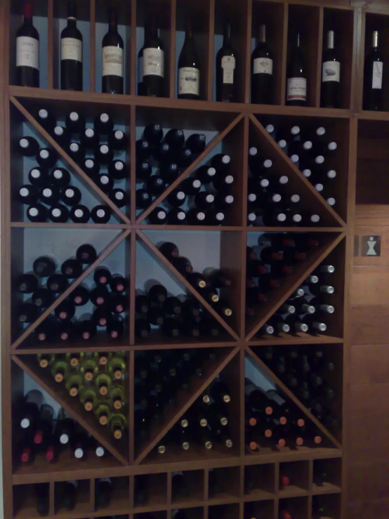 a wine display with bottles on wooden shelves