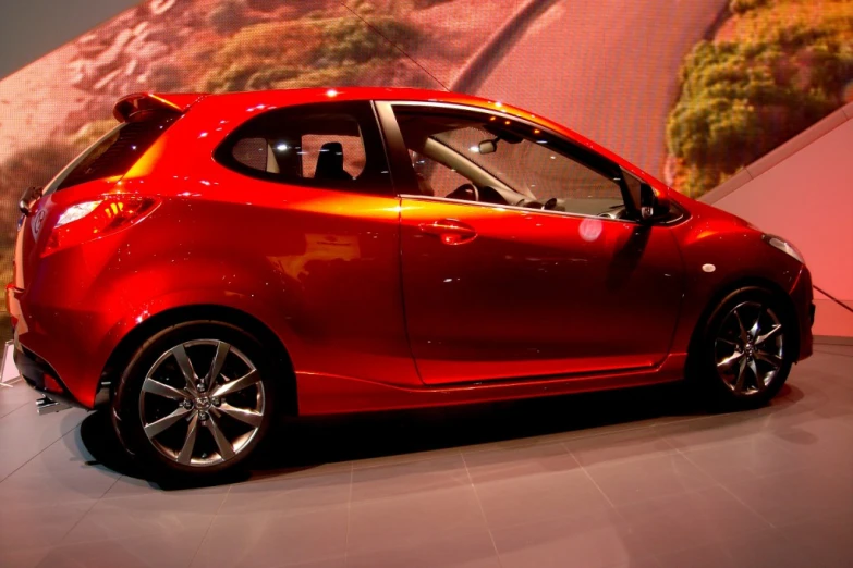 a red car parked next to a wall