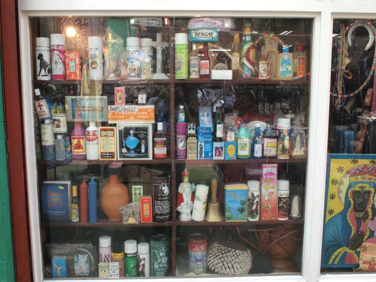 bottles and candles sitting inside of a display case