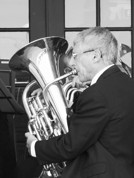 a man is playing a trumpet with a black and white background