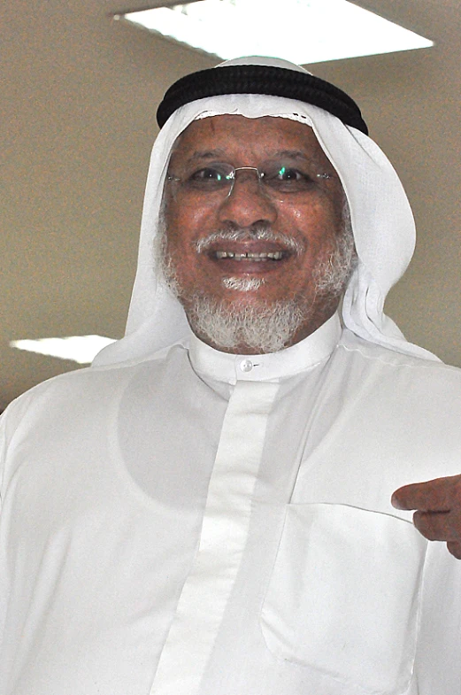a man in a white shirt with a beard and a white shawl
