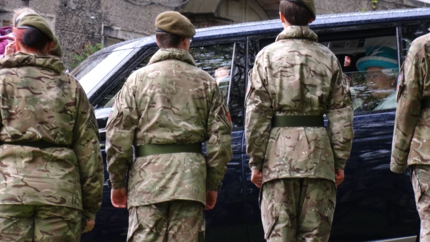 a number of soldiers standing next to a van