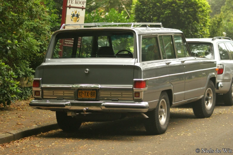 a car parked next to another one in front of trees