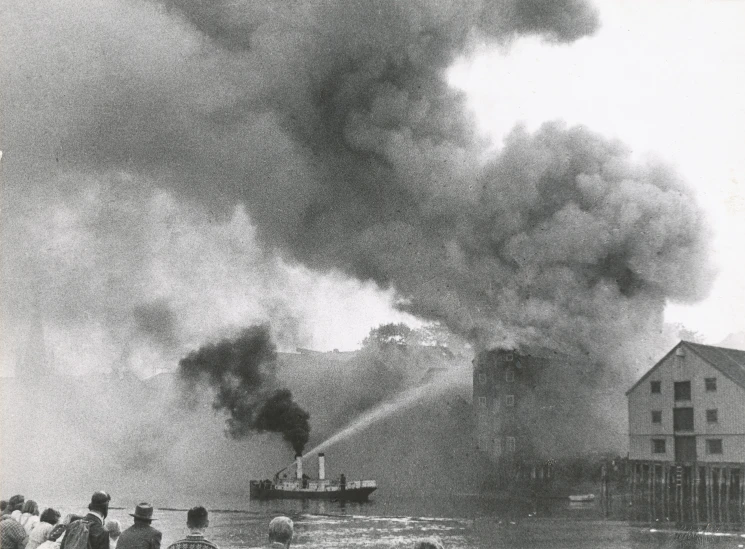 people watch as a boat goes by with a huge amount of smoke behind them