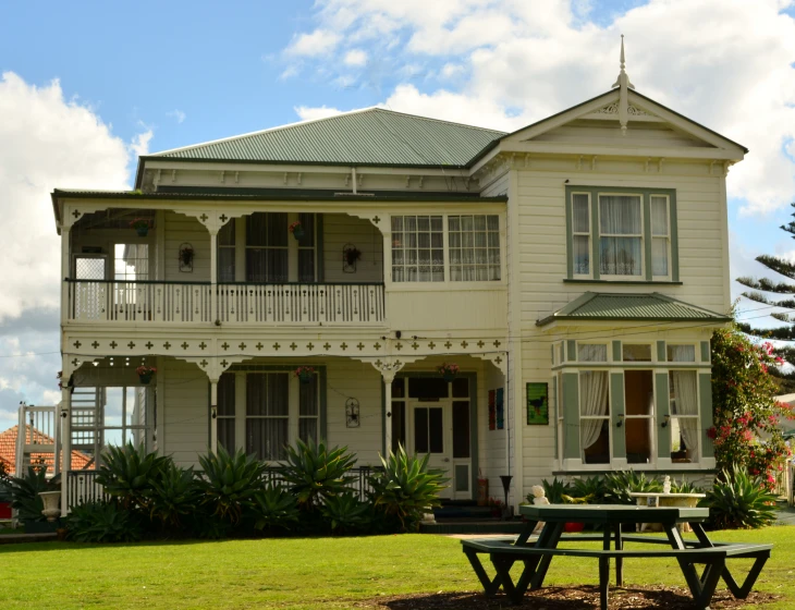 this is an old victorian home with a picnic table