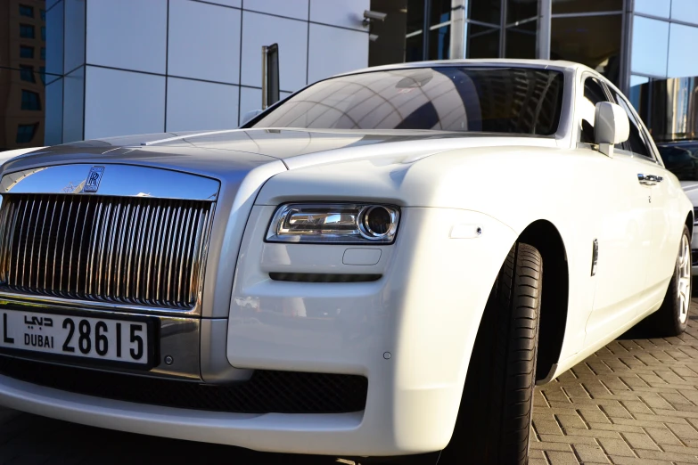 a white rolls royce on the side of the street