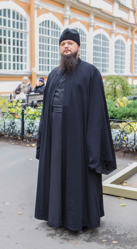 the man in black is dressed up like a priest