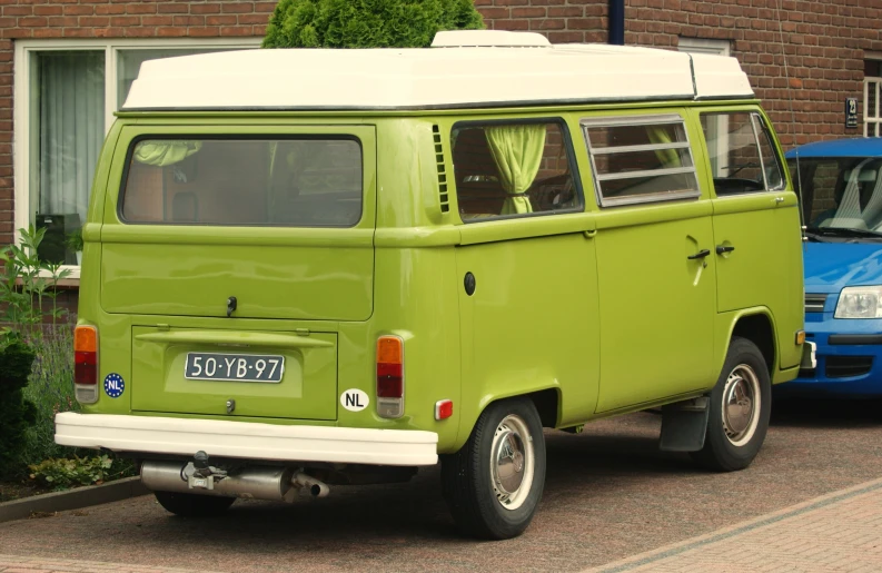 the bright green van is parked beside a blue van