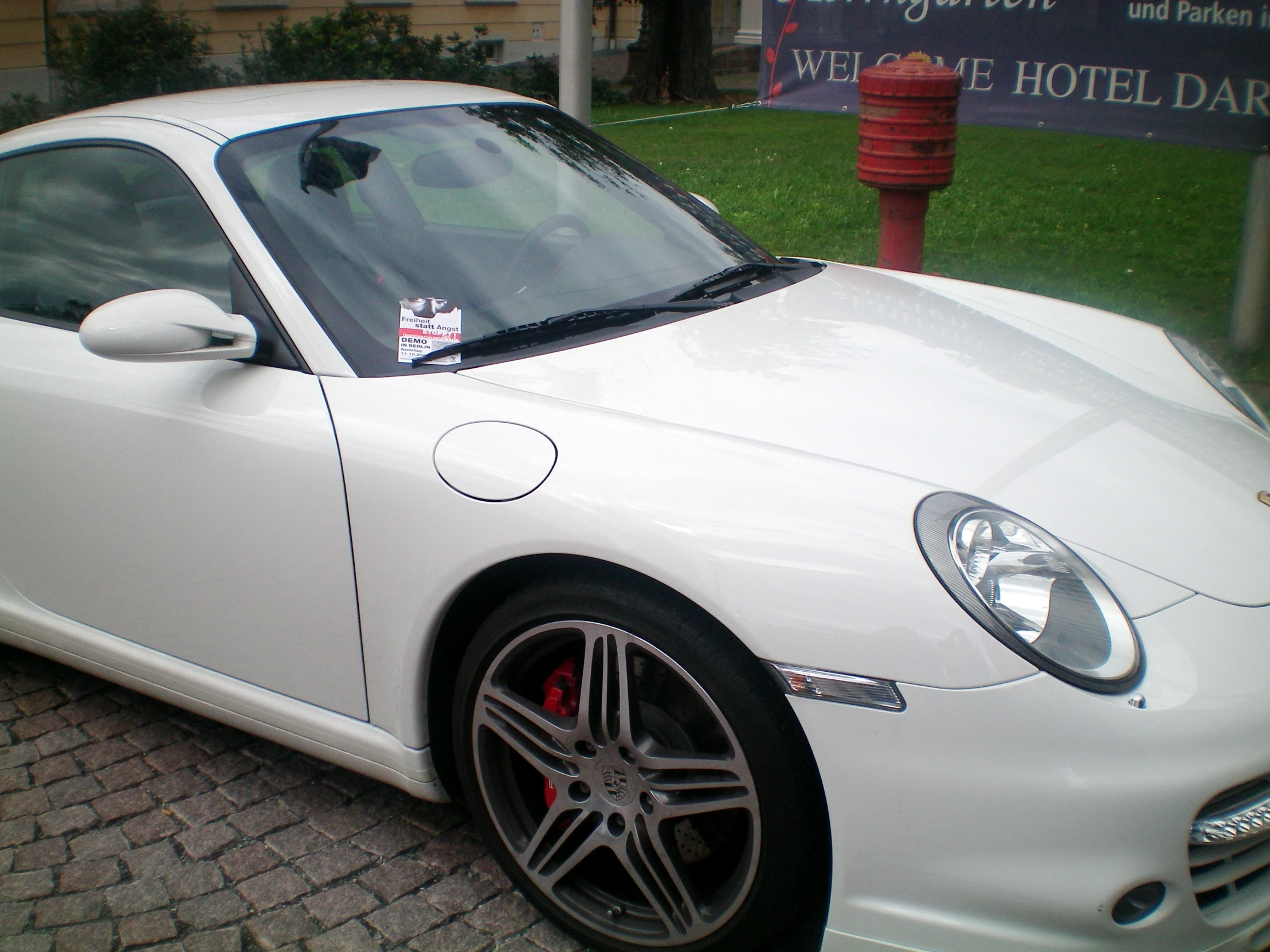 a white sports car parked on the side of the street