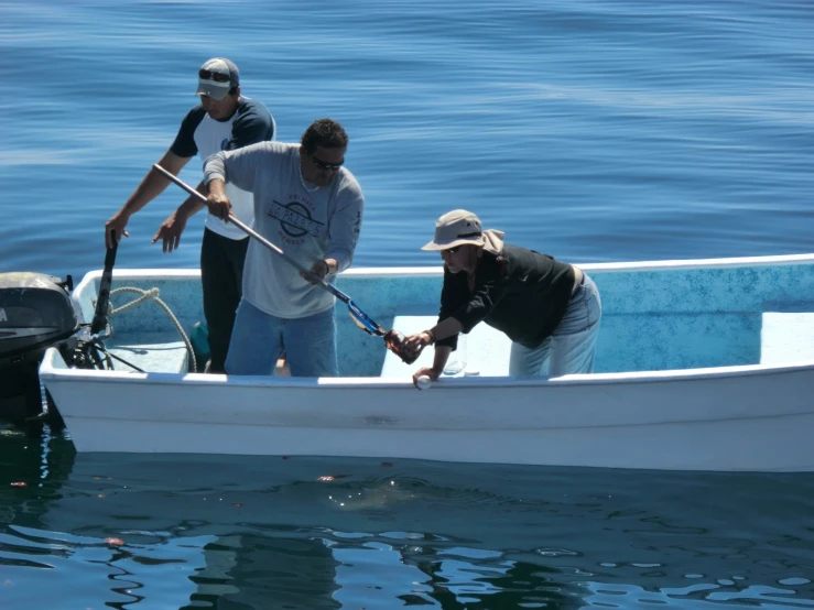 three people standing in the side of a boat