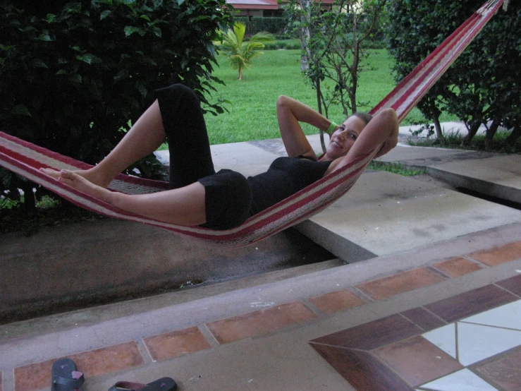 a man lying in a red and white hammock