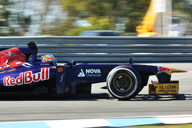 a man driving on a race car with red bull livery