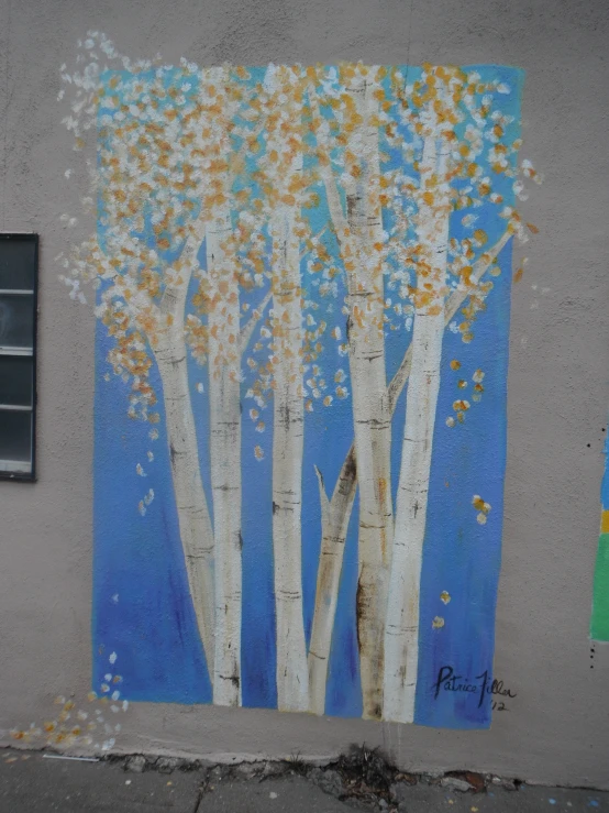 a painting on the side of a building with a tree painted on it