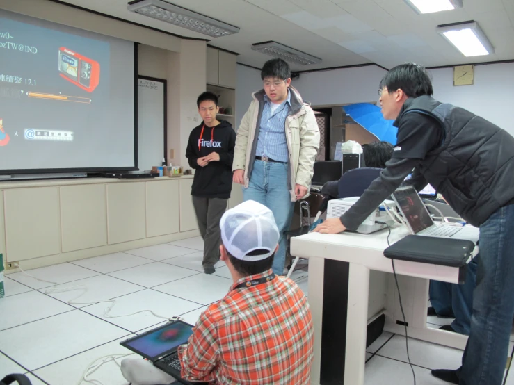 two people are standing and a man is standing near a table