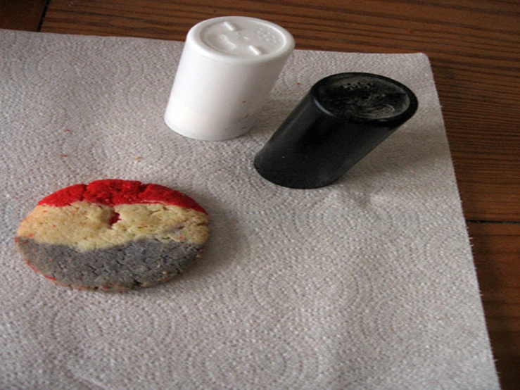 a piece of paper next to two white containers on a table