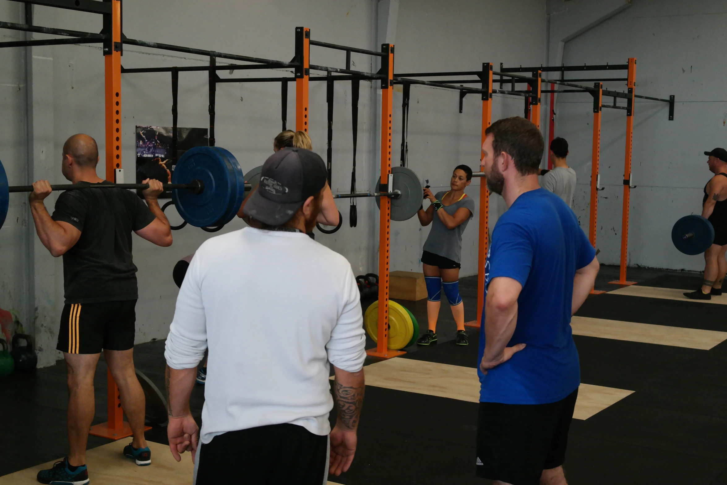 a group of people doing various exercises in a gym