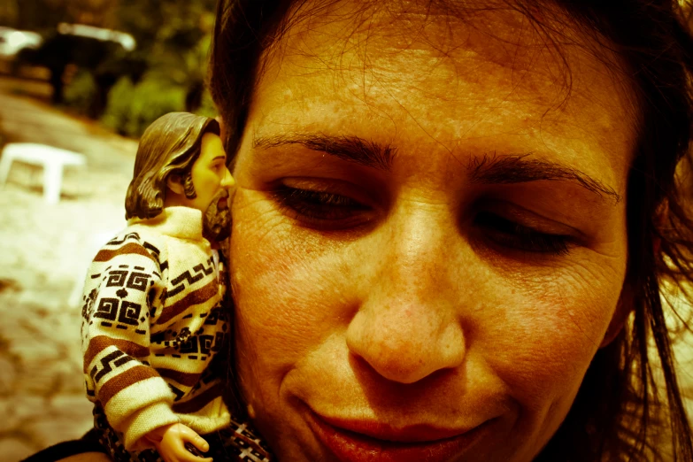 a woman holding a plastic monkey on the head of a figurine