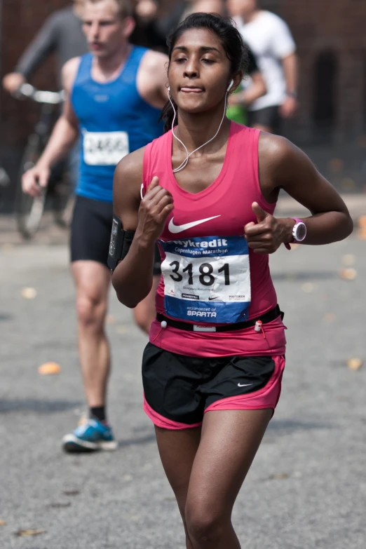 the woman is running alone while other people run