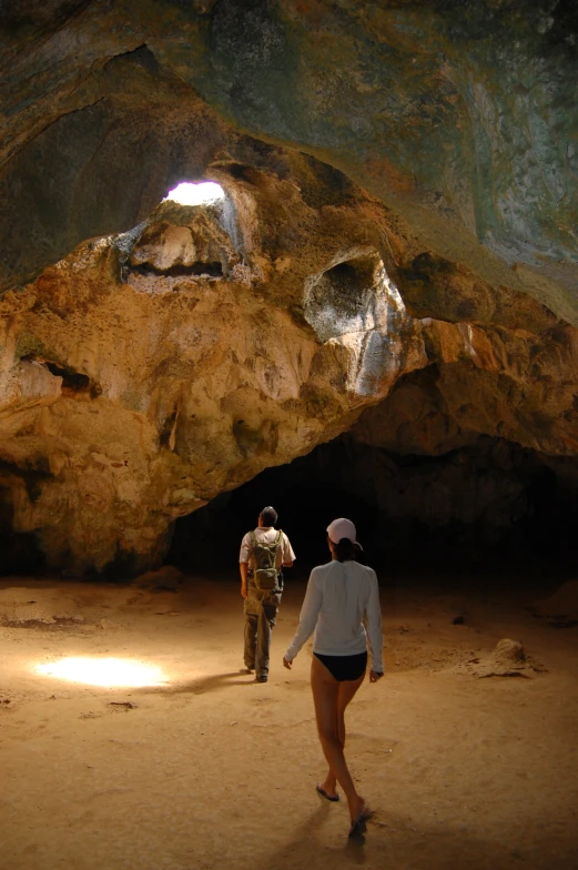 a man standing next to a woman in a cave