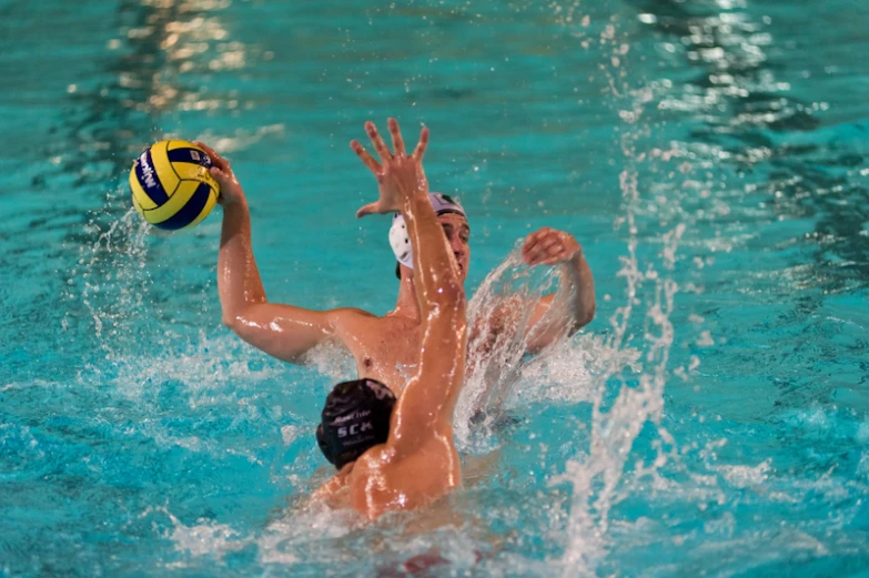 two people playing with a ball in water