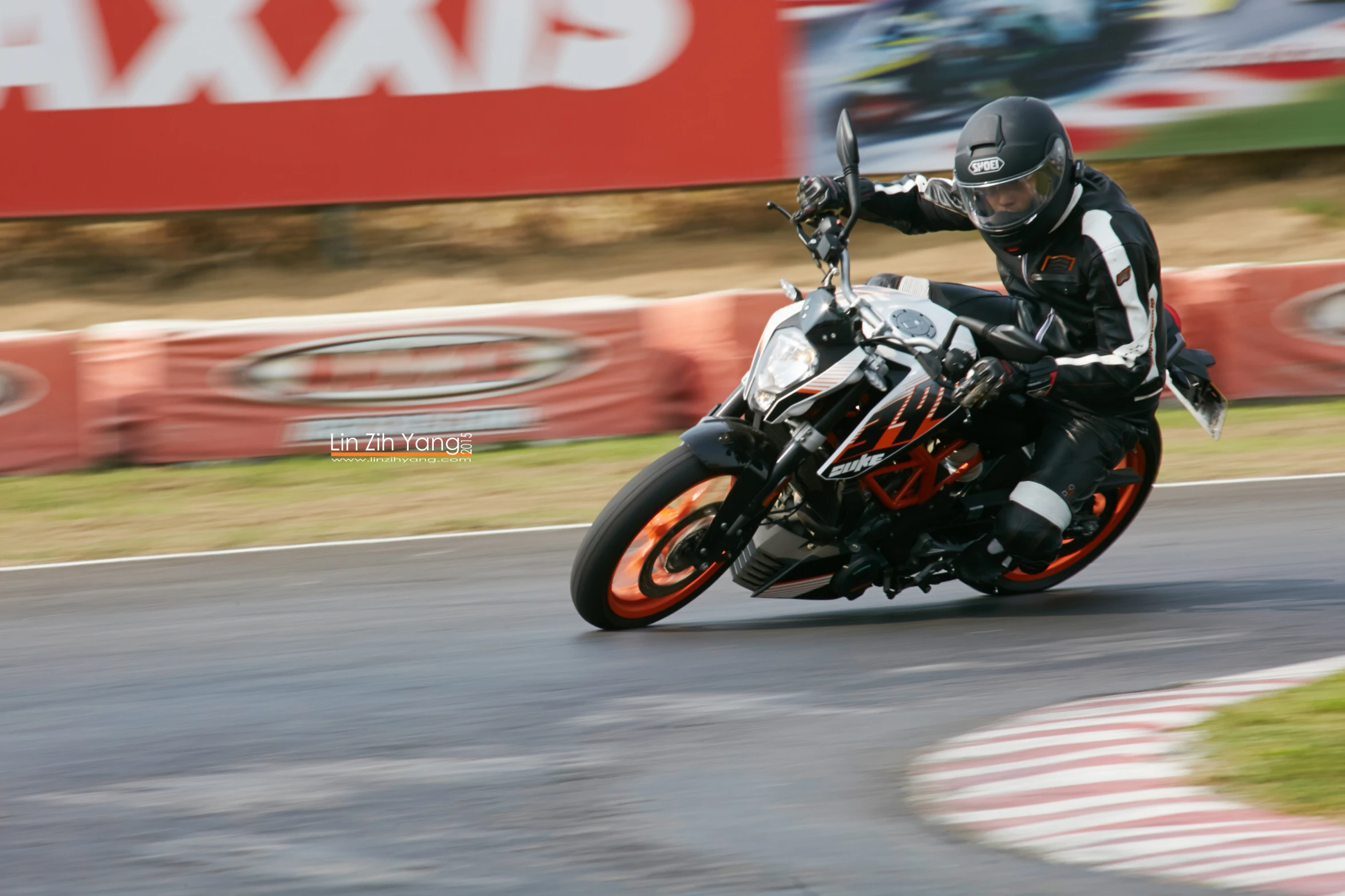 person riding motorcycle on race track near a stadium sign