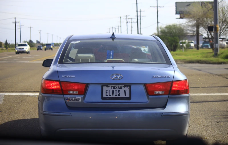 the back view of a car that is stopped at an intersection